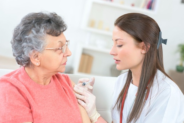 Grippe, krank, Influenza, impfen, Schutzimpfung, Vorsorge, behandeln, Krankenschwester, Seniorin, Pflege, Schutzhandschuhe, Injektion, injizieren, Spritze
