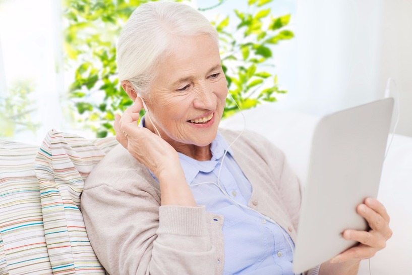 Senioren nutzen zunehmend Tablets. Inzwischen gibt es sogar spezielle Geräte für ältere Menschen. hören, Tablet, Kopfhörer, Tinnitus, schwerhörig, Frau, Ohr, Alter